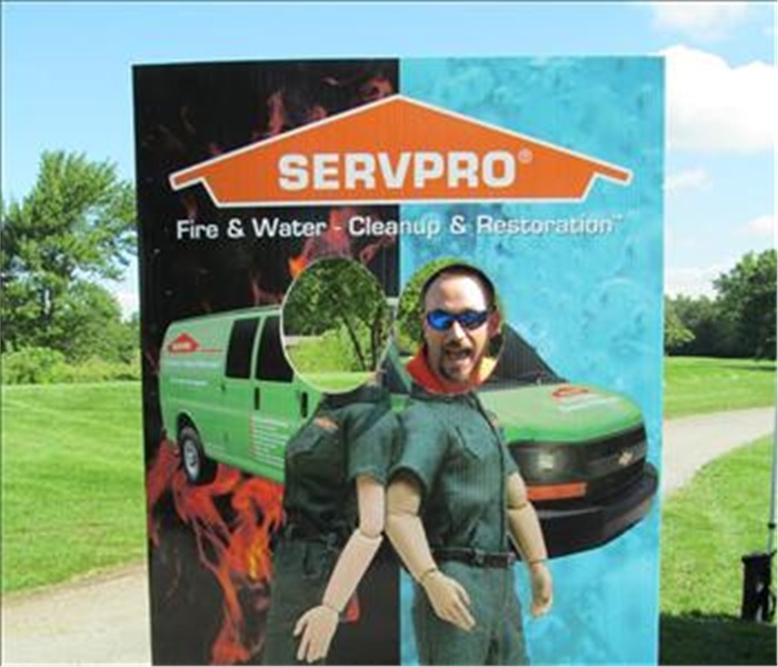 SERVPRO cardboard sign with two holes to stick your head in and a male employee in one hole