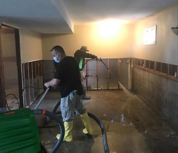 Technicians cleaning a floor in a basement